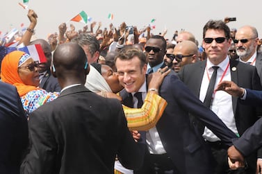Emmanuel Macron, centre, is greeted as he arrives to attend a ceremony to lay the first brick of the Bouake market in Ivory Coast earlier this month. AFP