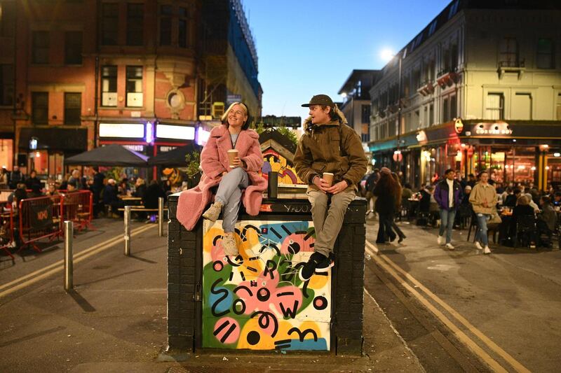 People drink coffee in the street in the Northern Quarter of central Manchester. AFP