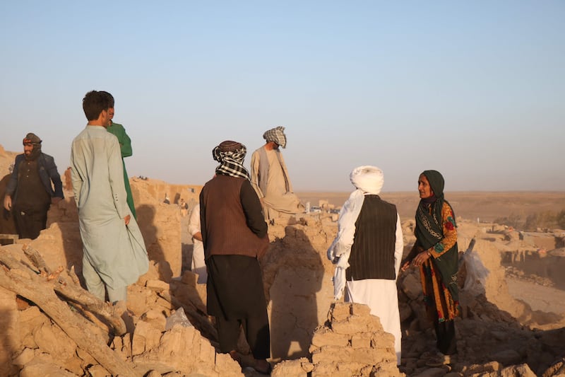 Afghan residents clear debris from a damaged house after an earthquake in the Sarbuland village of Zendeh Jan district. AFP