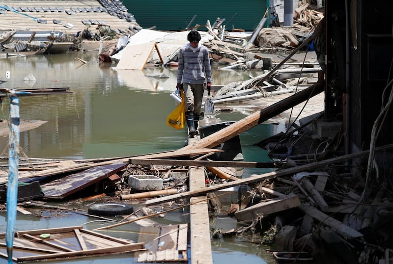 A local resident walks in a flooded area in Kurashiki, Okayama. Reuters