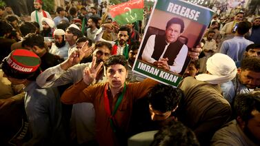 Pakistan Tehrik-e-Insaf party supporters hold a picture of Imran Khan as they demand his release, in Peshawar on May 9. EPA
