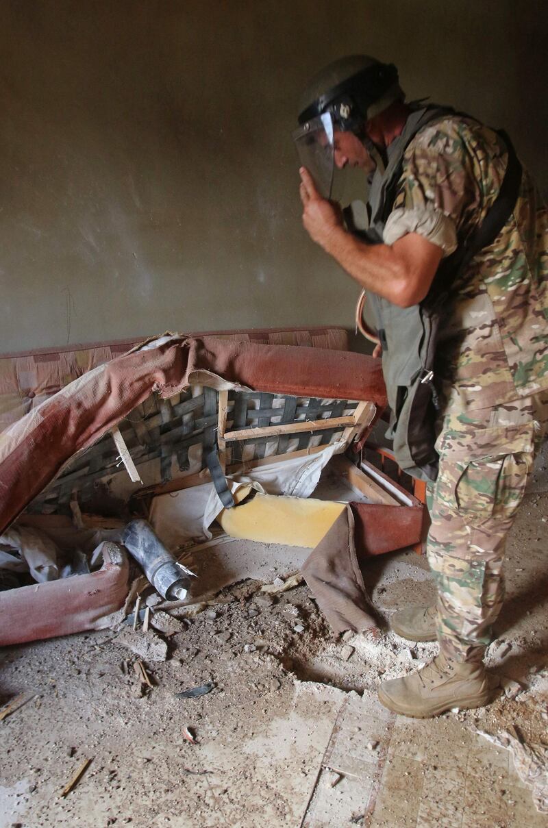 A bomb expert from the Lebanese army inspects an unexploded ordnance inside a home in Hebarieh village, after reported Israeli bombardment of the Shebaa Farms area. AFP