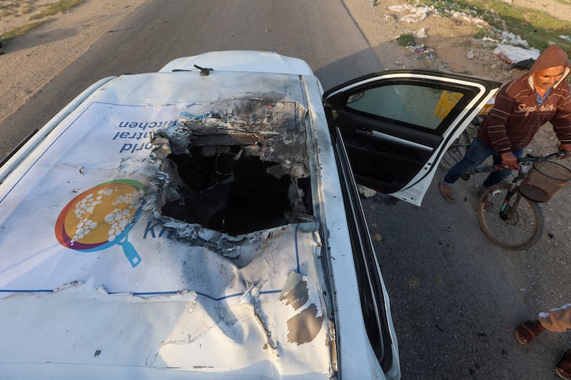 A man rides a bicycle, on April 2, past a damaged vehicle where employees from the World Central Kitchen non-profit, including foreigners, were killed in an Israeli air strike. Reuters