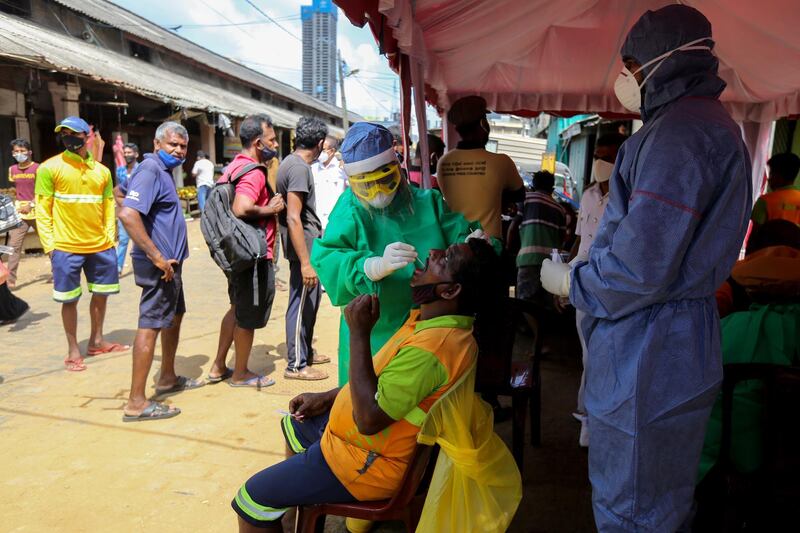 Sri Lankan health workers carry out Covid-19 swab tests at a public market in Colombo, Sri Lanka. EPA