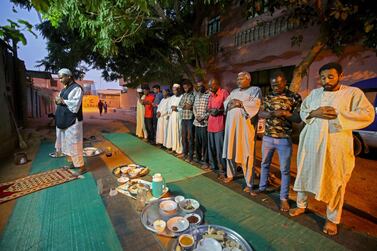 Sudanese men gather in prayers in a street in the capital Khartoum after breaking their fast during Ramadan on April 25, 2020 amid a curfew due to the Covid-19 coronavirus pandemic. AFP