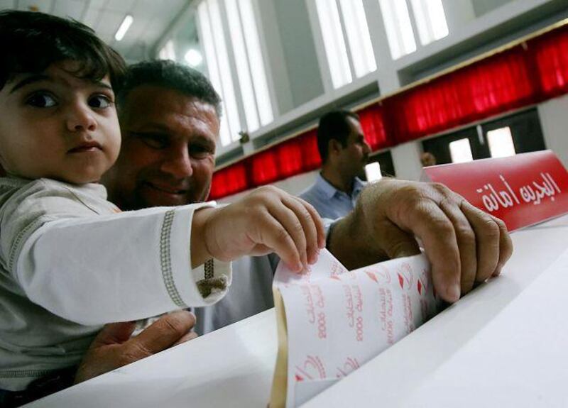 A Bahraini man and his son cast a ballot during the 2006 November elections