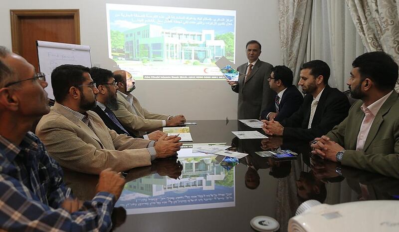 Dr Asjad Hameed, director of the proposed Diabetes Centre in Islamabad, standing, discusses the progress of the hospital with members of the fund-raising committee in Abu Dhabi. Ravindranath K / The National