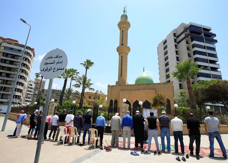 Worshippers pray outside a closed mosque in the port city of Sidon, Lebanon. Reuters