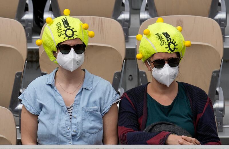 Tennis fans wearing a tennis ball style hats and face masks, watch Sloane Stephens play Karolina Muchova in the the French Open tennis tournament at Roland Garros in Paris, France. AP Photo