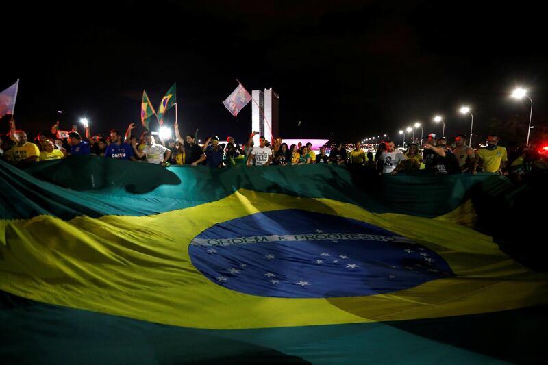 Supporters of Jair Bolsonaro react after Bolsonaro won the presidential race, in Brasilia. Reuters