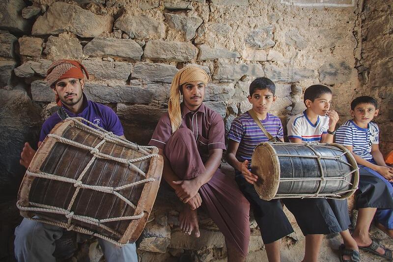 Boys play their grandfathers’ drums outside the courtyard where shuwah cooks underground. Ania James for The National