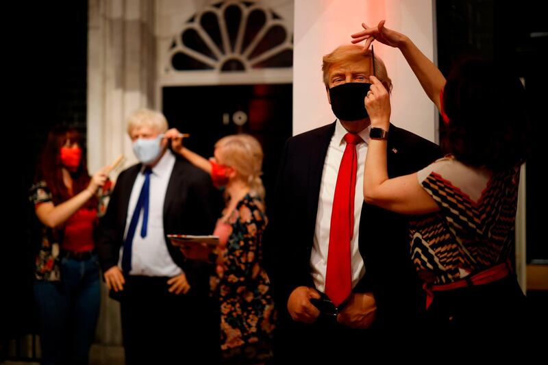 TOPSHOT - Artists put the finishing touches to wax figures Britain's Prime Minister Boris Johnson and US President Donald Trump as Madame Tussauds prepares to reopen its doors to the public on July 30, 2020 following the easing of coronavirus lockdown restrictions in England. / AFP / Tolga Akmen

