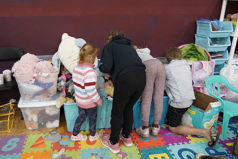 Children pick out toys from a donation box at the sports complex where Ukrainian refugees are staying in Tijuana.