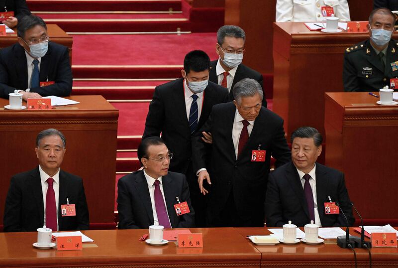 China's President Xi Jinping, right, sits beside Premier Li Keqiang, second left, as former president Hu Jintao, second right, is escorted from the closing ceremony of the congress. AFP