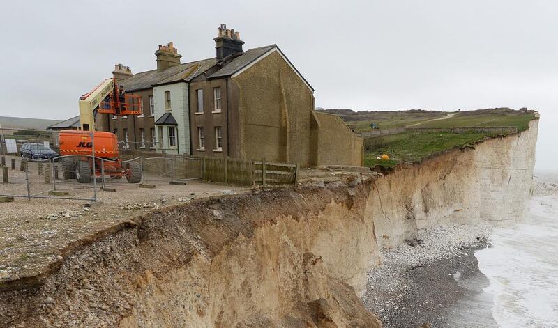 Work begins on March 19, 2014 to demolish a cottage at Birling Gap which was at risk of collapsing due to coastal erosion caused – at least in part – by climate change. Mike Hewitt / Getty Images
