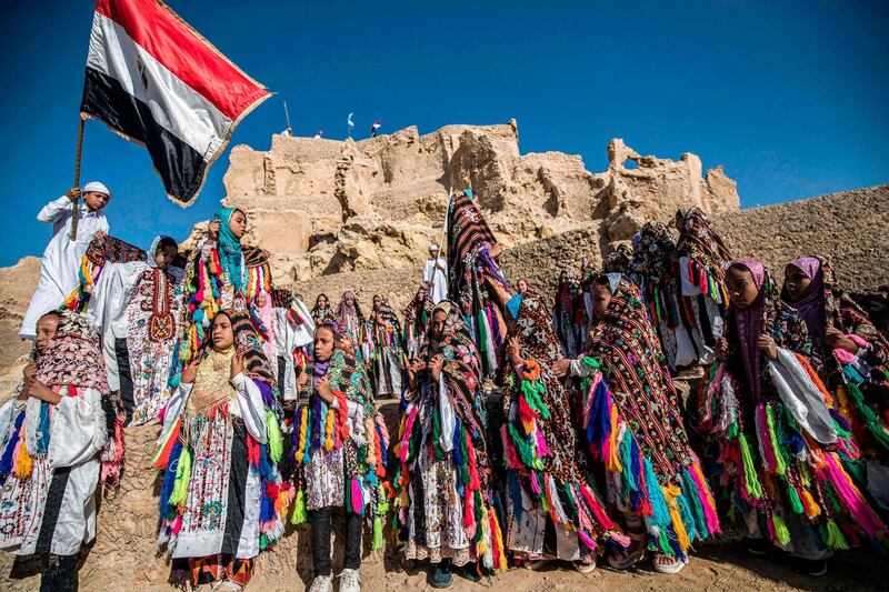 Egyptian schoolchildren, dressed in traditional outfits, gather during a celebration to mark the inauguration of the fortress of Shali following its restoration. AFP