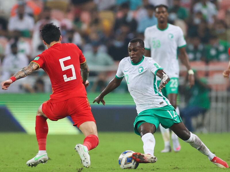 Saud Abdulhamid (R) is challenged by China defender Zhang Linpeng as he brings the ball out from the back to start an attack. AFP