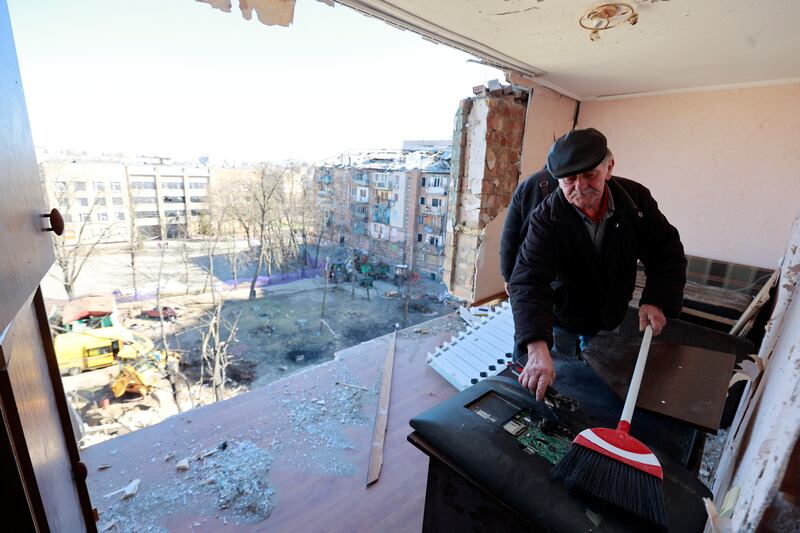 Men attempt to clean a room in an apartment building destroyed during an air raid in Kyiv, amid Russia's invasion of Ukraine. Reuters