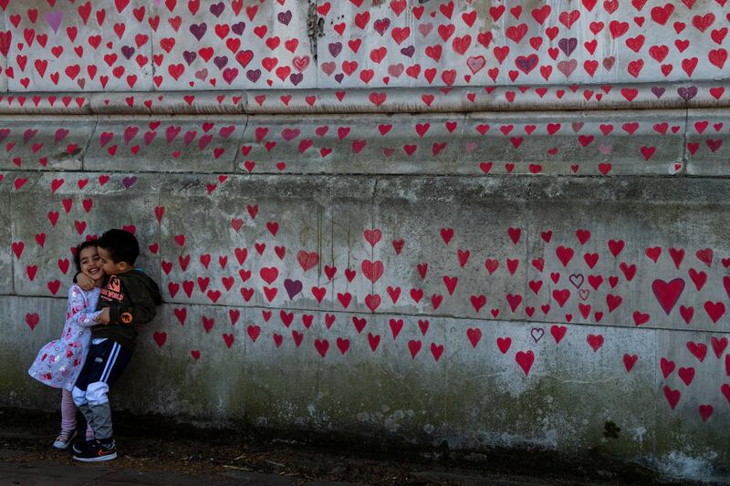 Brother and sister Amira, 3, and Adem Atia, 4, stand in front of the Covid-19 memorial wall. Getty Images
