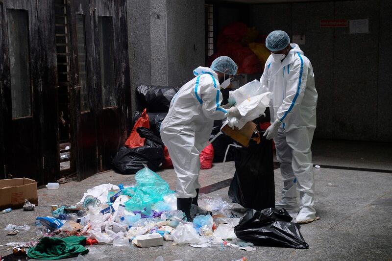 Medical and laboratory staff wearing personal protection equipment (PPE) collect medical waste during a coronavirus screening at the dedicated Covid-19 facility of the civil hospital in Nashik, Maharashtra.  AFP