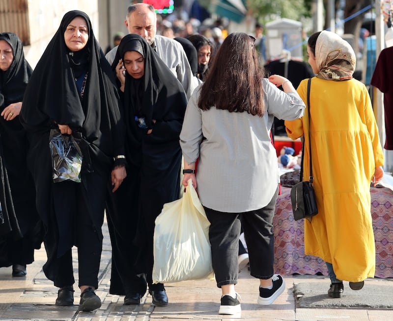 Veiled Iranian women walk next to a woman without a headscarf in Tehran. EPA