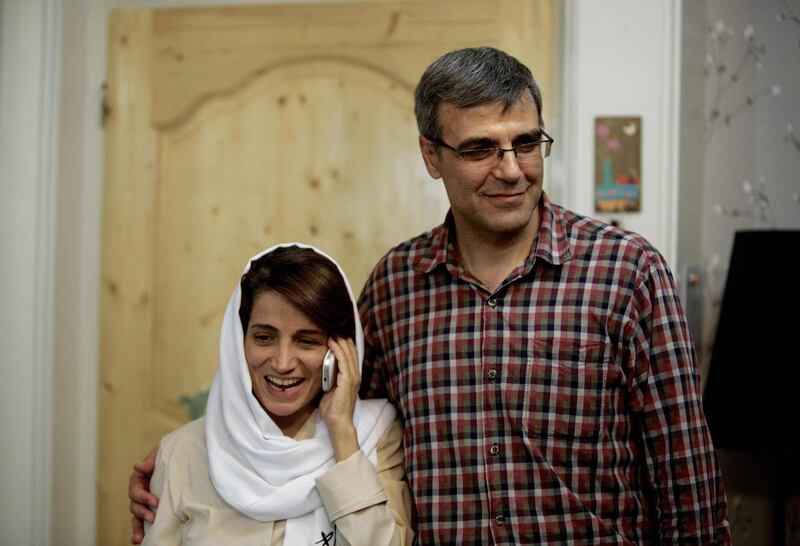(FILES) In this file photo taken on September 18, 2013 Iranian lawyer Nasrin Sotoudeh (L) speaks on the phone next to her husband Reza Khandan as they pose for a photo at their house in Tehran after Nasrin was freed following three years in prison.  Iranian lawyer Nasrin Sotoudeh, a well known human rights activist imprisoned in Tehran, was sentenced to seven years in prison, the semiofficial ISNA news agency reported on March 11, 2019.  / AFP / BEHROUZ MEHRI
