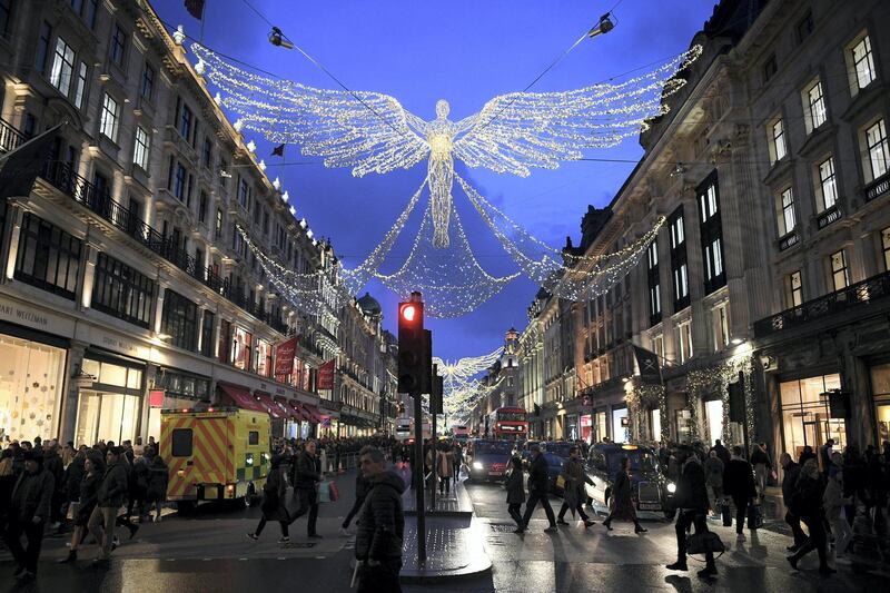 Shoppers walk below the Christmas lights along Regent Street in central London on December 21, 2019, on the last Saturday before Christmas. (Photo by DANIEL LEAL-OLIVAS / AFP)