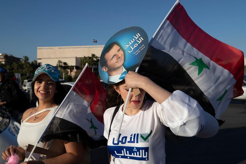 A supporter of Bashar Al Assad holds up a picture of the Syrian president with the slogan 'Assad is the hope', at Umayyad Square. AP Photo