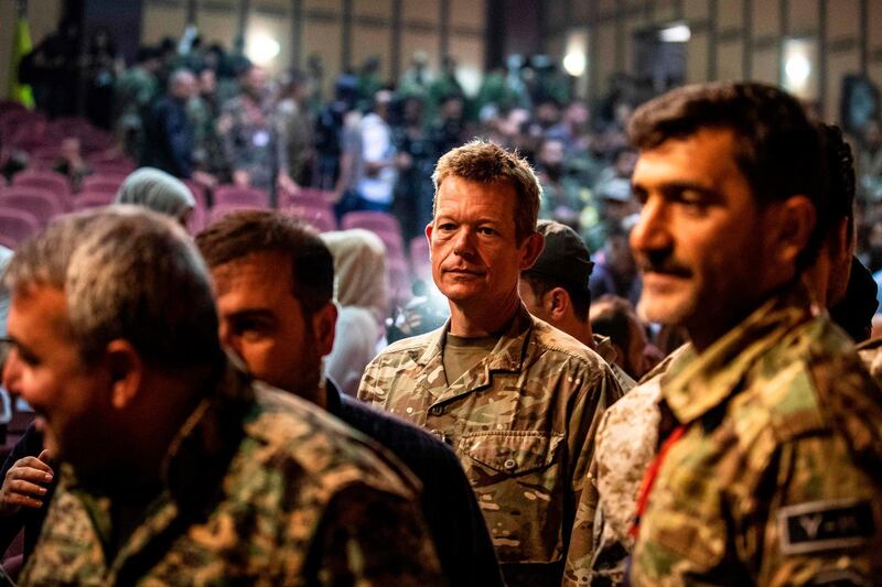 Brigadier-General Nicholas Pond (C), a representative of the US-led coalition fighting the Islamic State (IS) group, attends a meeting with commanders of the Syrian Democratic Forces (SDF) in the northwestern Syrian city of Hasakah, in the province of the same name, on August 24, 2019. Syria's Kurds said on August 24 that they would support the implementation of a US-Turkey deal to set up a buffer zone in their areas along the Turkish border. The so-called "safe zone" agreed by Washington and Ankara earlier this month aims to create a buffer between the Turkish border and Syrian areas controlled by the Kurdish People's Protection Units (YPG). The YPG have played a key role in the US-backed battle against the Islamic State group in Syria, but Ankara views them as "terrorists". / AFP / Delil SOULEIMAN
