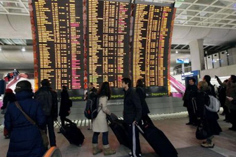 Travellers look at the departure board on December 22, 2010 at the Charles de Gaulle airport in Roissy, as 25% of the flights have been cancelled because of poor weather conditions. In London, Paris and Frankfurt, the continent's busiest airports were running a slimmed-down schedule in a bid to get thousands of weary travellers to their destinations before Christmas Day on Saturday.    AFP PHOTO / PIERRE VERDY
 *** Local Caption ***  928769-01-08.jpg