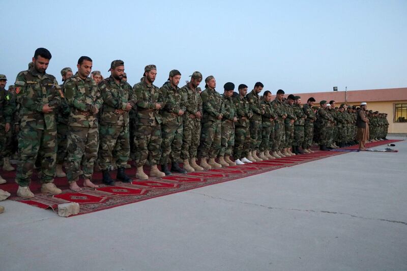 Soldiers of the Afghan National Army pray after ending their fast in Herat, Afghanistan. EPA
