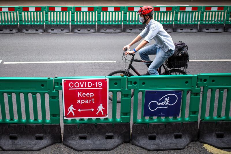 LONDON, UNITED KINGDOM - JUNE 12: A cyclist passes along Oxford Street where barriers have been installed to widen the pavement to enable social distancing on June 12, 2020 in London, England.  As the British government further relaxes Covid-19 lockdown measures in England, this week sees preparations being made to open non-essential stores and Transport for London handing out face masks to commuters. International travelers arriving in the UK will face a 14-day quarantine period. (Photo by Justin Setterfield/Getty Images)