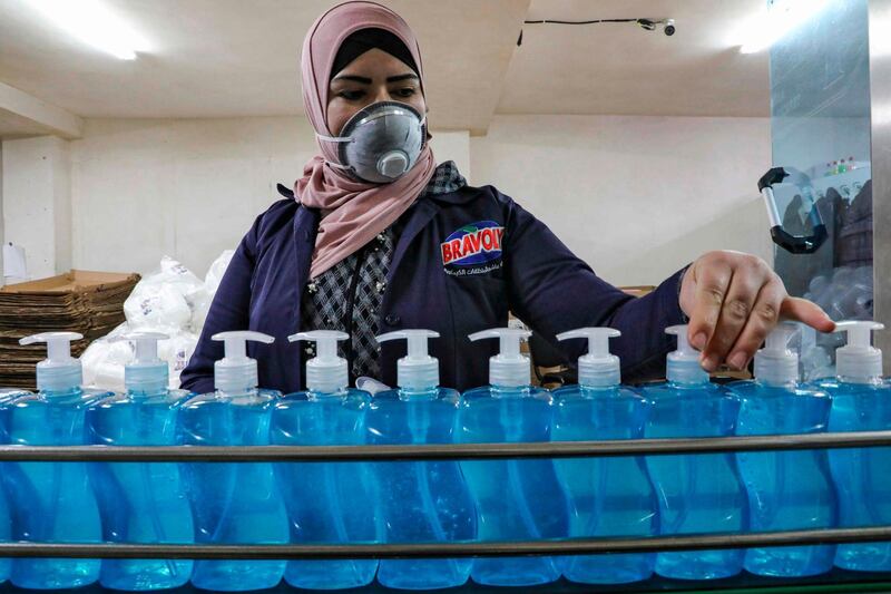 A Palestinian factory worker checks hand sanitiser bottles on a production line in the flashpoint city of Hebron in the occupied West Bank on March 9, 2020.  AFP