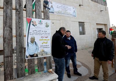 FILE PHOTO: Men stand next to a poster of Palestinian Omar Asaad in Jiljilya village in the Israeli-occupied West Bank on January 12. Reuters