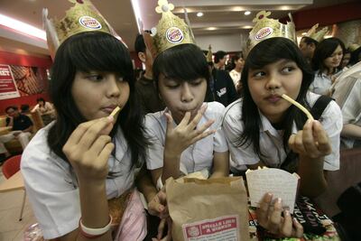 A group of young girls eat their Burger King meals on the opening day of the first Burger King Holdings Inc. fast food restaurant in Indonesia, at the Senayan City shopping mall in Jakarta, on Thursday, April 26, 2007.  Burger King Holdings Inc., the world's second-largest burger chain, will open fast food restaurants in Japan and Hong Kong next.  Photographer: Dimas Ardian/Bloomberg News