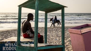 A woman takes a horse ride along a beach in Banjul, Gambia. AFP