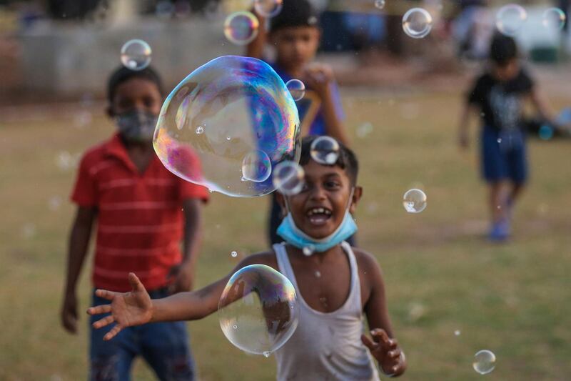 Sri Lankan children play with bubbles at the Galle Face sea promenade in Colombo, Sri Lanka. EPA