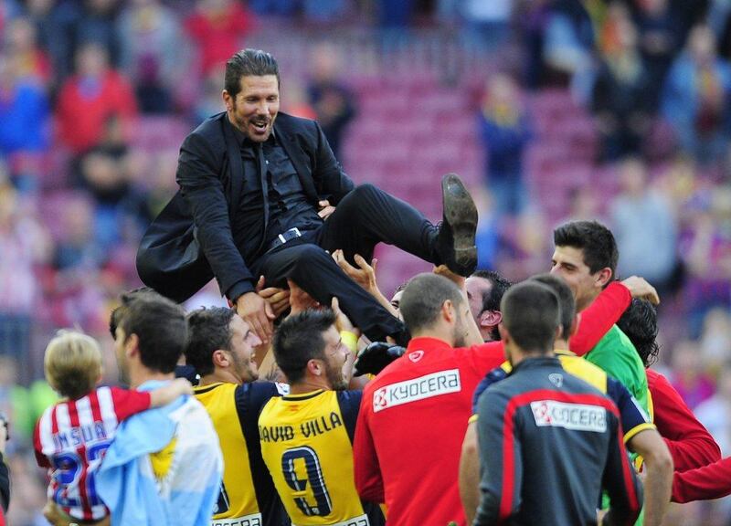 Players lift Atletico Madrid manager Diego Simeone following their 1-1 draw with Barcelona that sealed the La Liga title for them. Manu Fernandez / AP / May 17, 2014