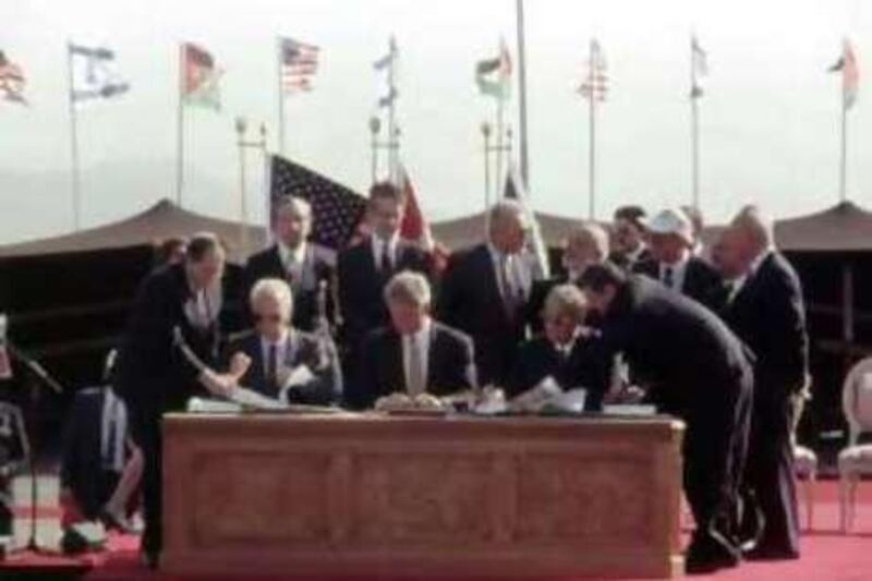 American President Bill Clinton, center, Israeli Prime Minister Yitzhak Rabin, left, and Jordanian Prime Minister Abdul-Salam Majali, right, sign the Peace Treaty between Israel and Jordan during signing ceremony at the Wadi Araba, on the Israel-Jordan border crossing, near Eliat, Oct. 26, 1994. The treaty brings to an end a 46 year state of war between the two countries. U.S. Secretary of State Warren Christopher, stands second from left at back and King Hussein of Jordan is fifth from left. Others in the picture are American, Israeli and Jordanian government representatives. (AP Photo/Staff/Nightswander)