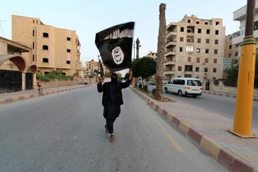 An ISIS member waves the extremist group's flag in Raqqa, Syria 2014. Reuters