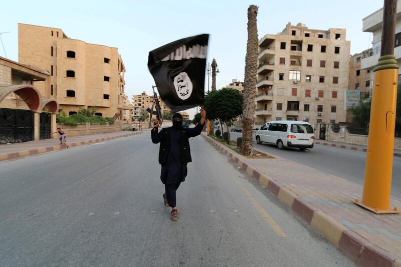 FILE PHOTO - A member loyal to the Islamic State in Iraq and the Levant (ISIL) waves an ISIL flag in Raqqa, Syria June 29, 2014. REUTERS/Stringer/File Photo