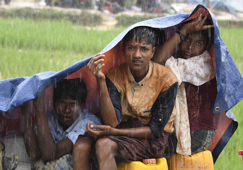 Rohingya refugees protect themselves from the rain in Bangladesh's Balukhali refugee camp. Dominique Faget / AFP Photo