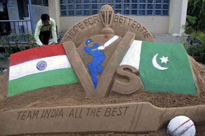 Indian artist Subala Moharana gives final touches to a sand sculpture on the eve of the India-Pakistan Cricket World Cup semi-final match in 2011