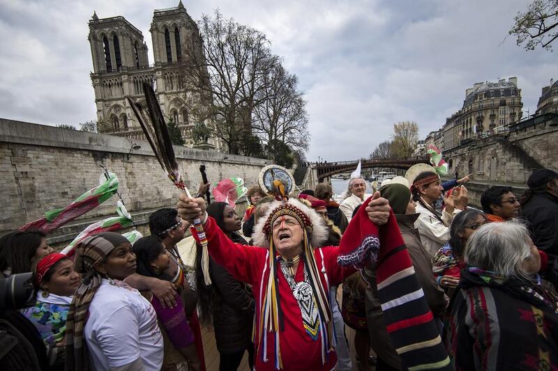 Indigenous representatives from around the world engage in a joint prayer session on board of a river boat on the Seine river, as part of a campaign to draw attention to the plight of indigenous tribes facing climate change on the sidelines of the COP21 Climate Conference, in Paris. EPA