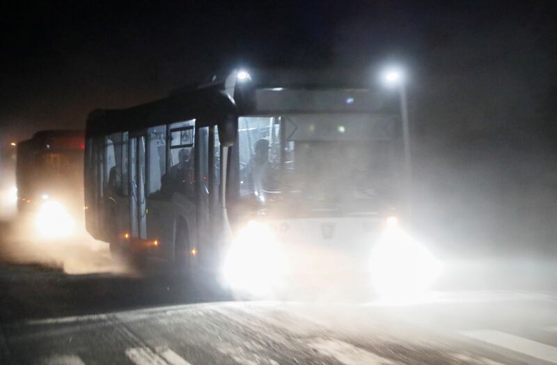 Buses carrying Ukrainian soldiers from the besieged Azovstal steel mill drive away under escort of the pro-Russian forces, in Mariupol. Reuters