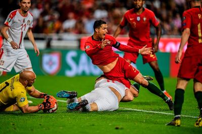 TOPSHOT - Portugal's forward Cristiano Ronaldo (C) vies with Serbia's defender Nikola Milenkovic (BOTTOM) during the Euro 2020 qualifying group B football match between Portugal and Serbia at the Luz stadium in Lisbon on March 25, 2019.  / AFP / PATRICIA DE MELO MOREIRA
