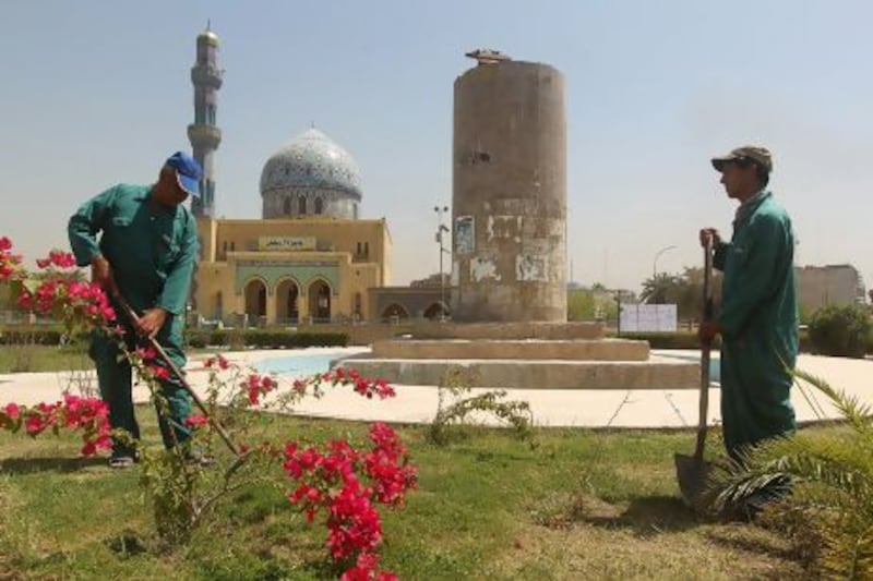 Iraqi workers garden near the pedestal from which the statue of late Iraqi president Saddam Hussein was famously toppled in the garden of Firdos Square in Baghdad.