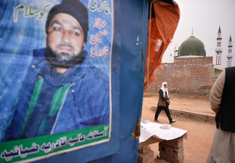 A portrait of Mumtaz Qadri, who was hanged last year for the murder of a governor who criticised Pakistan's blasphemy law, near a shrine to him that was built on the outskirts of Islamabad. Aamir Qureshi/AFP 

