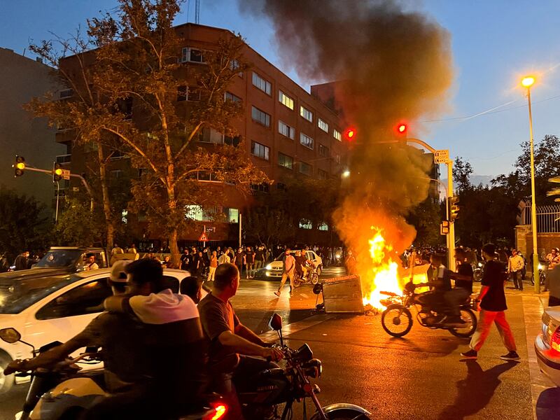 A police motorcycle burns during a protest over the death of Mahsa Amini. Reuters
