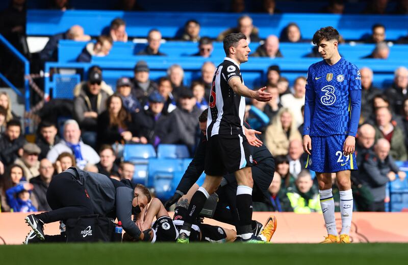 Newcastle defender Dan Burn receives treatment after being caught in the face by an elbow off Chelsea's Kai Havertz. Reuters